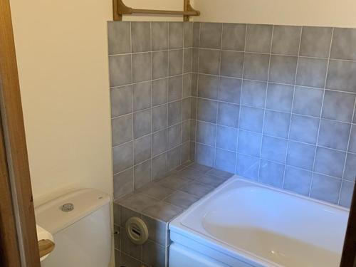 a small bathroom with a tub and a toilet at Appartement Saint-Jean-d'Aulps, 2 pièces, 6 personnes - FR-1-573-58 in Saint-Jean-d'Aulps