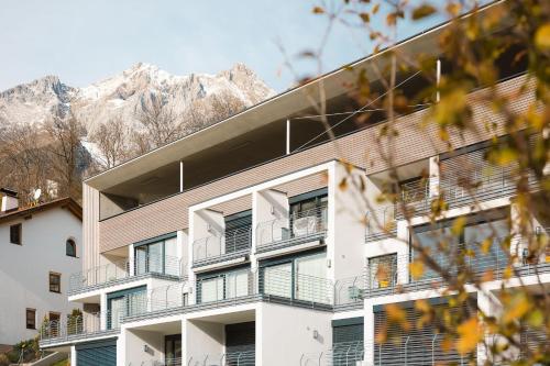 un edificio con balcones con montañas en el fondo en Apart Momente, en Grins