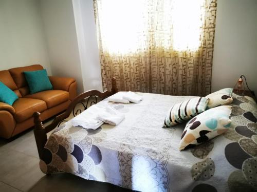 a bedroom with a bed and a couch at Escape and relax cozy apartment in Pafos! in Mandria