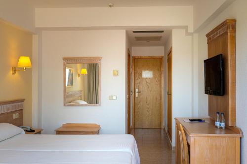 a hotel room with a bed and a television at Hotel Santa Maria Playa in Cala Millor