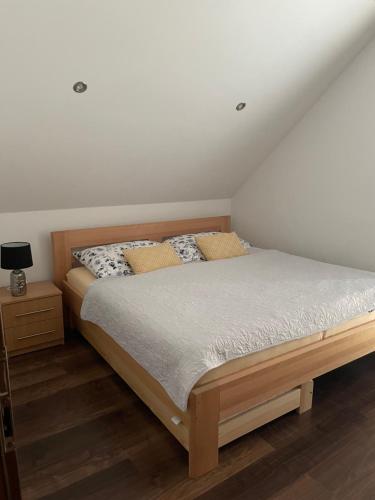 1 dormitorio con 1 cama con marco de madera en StellaHouse, en Radešín