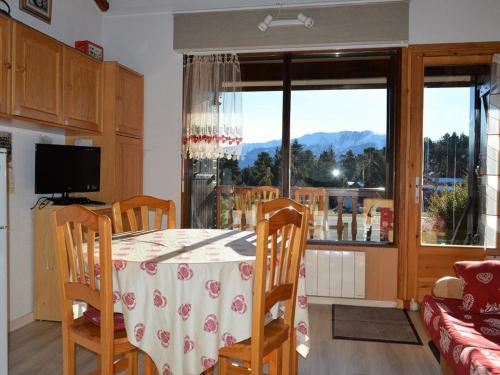 une salle à manger avec une table et une vue sur les montagnes dans l'établissement Chalet familial 2 pièces pour 4 pers. à 500m des pistes avec terrasse et équipements modernes - FR-1-592-23, à Bolquère-Pyrénées 2000