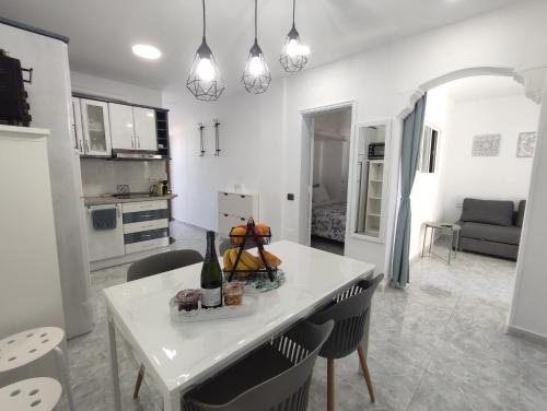 a kitchen and living room with a white table and chairs at Vivienda Agaete Parque in Playa del Ingles