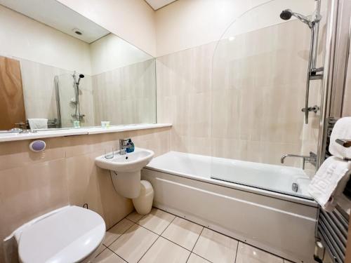 een badkamer met een toilet, een wastafel en een bad bij Queen Street City Centre Apartment in Glasgow