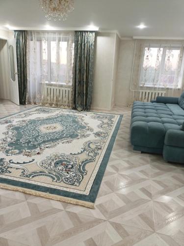 ein Wohnzimmer mit einem Sofa und einem großen Teppich in der Unterkunft 2-х комнатная квартира посуточно in Kökschetau