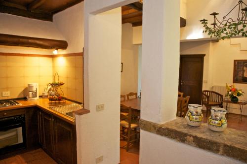 a kitchen with a counter and a dining room at Borgo Il Poggiaccio Residenza d'Epoca in Sovicille