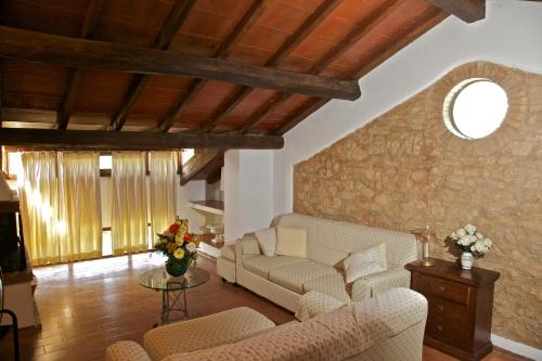 a living room with couches and a stone wall at Borgo Il Poggiaccio Residenza d'Epoca in Sovicille