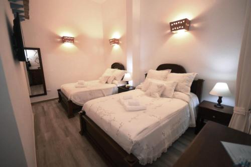 a hotel room with two beds and two lamps at Casona 1865 in Ráquira
