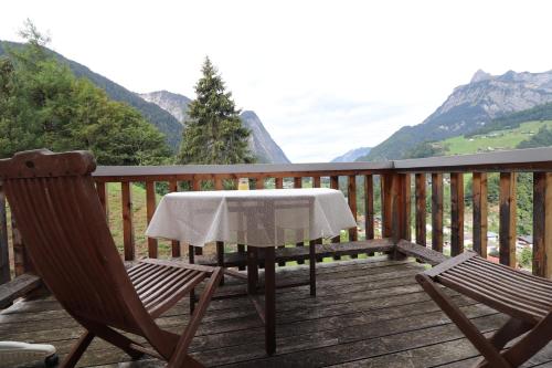 a table and two chairs on a deck with mountains at Bauernhof Wildfang in Dalaas