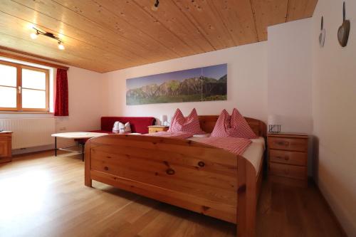 a bedroom with a large bed with pink pillows at Bauernhof Wildfang in Dalaas
