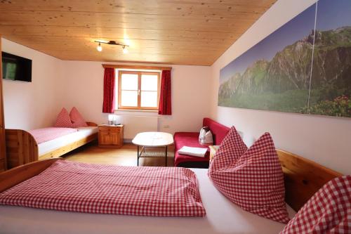 a room with a bed and a couch and a table at Bauernhof Wildfang in Dalaas