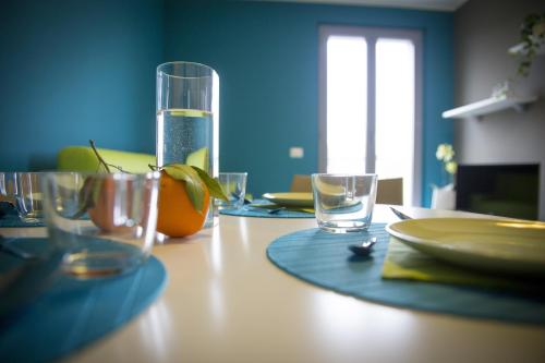 a wooden table with glasses and an orange on it at Dreams Hotel Residenza Pianell 10 in Milan