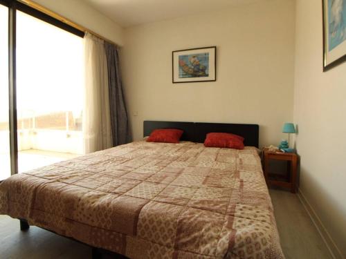 a bedroom with a bed with two red pillows at Appartement Royan, 2 pièces, 4 personnes - FR-1-494-89 in Royan