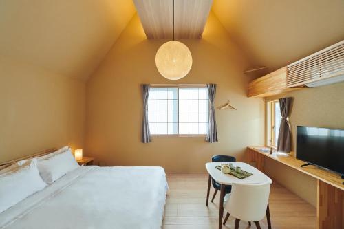 大阪市にある俪居花园酒店Reikyo Garden Hotelのベッドルーム(ベッド1台、テーブル、テレビ付)