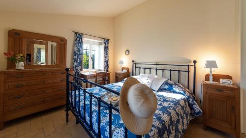 una camera da letto con un letto con un cappello sopra di LA CASA NEI VIGNETI 10, Emma Villas a Catignano