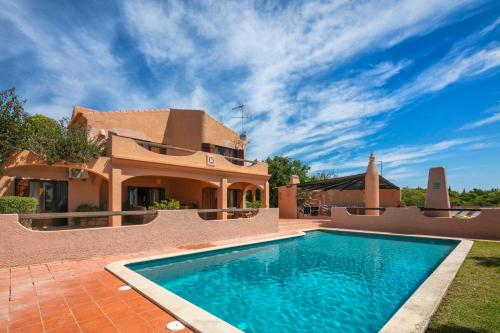 a house with a swimming pool in front of a house at Casa Monte Novo in Lagoa