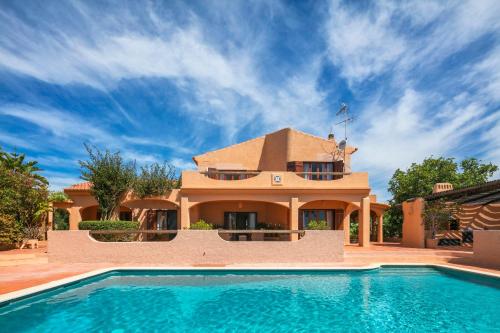 a house with a swimming pool in front of a house at Casa Monte Novo in Lagoa