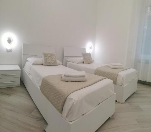 two beds in a bedroom with white walls at Residenze Niguarda E in Milan
