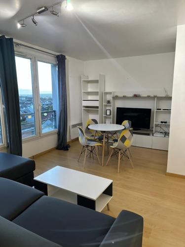 a living room with a table and chairs at Cosy appartement with free parking a Paris in Villejuif