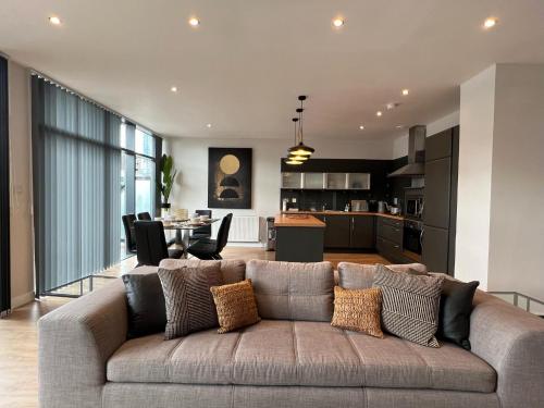 a living room with a couch and a kitchen at Stunning Apartment at Glasgow Hydro & SECC - Glasg in Glasgow