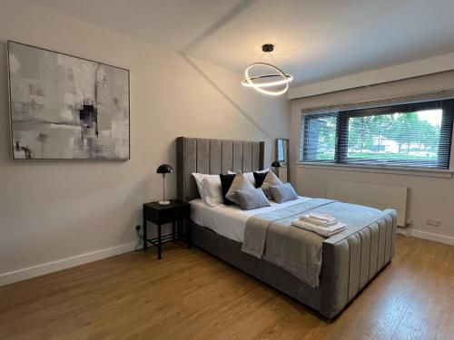 a bedroom with a bed and a large window at Stunning Apartment at Glasgow Hydro & SECC - Glasg in Glasgow