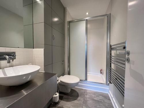 a bathroom with a sink and a toilet and a shower at Stunning Apartment at Glasgow Hydro & SECC - Glasg in Glasgow
