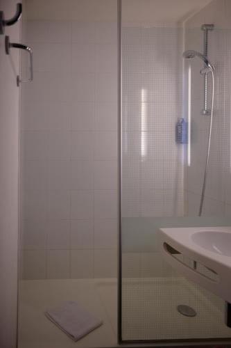 a shower with a glass door next to a sink at ibis Aix en Provence in Aix-en-Provence