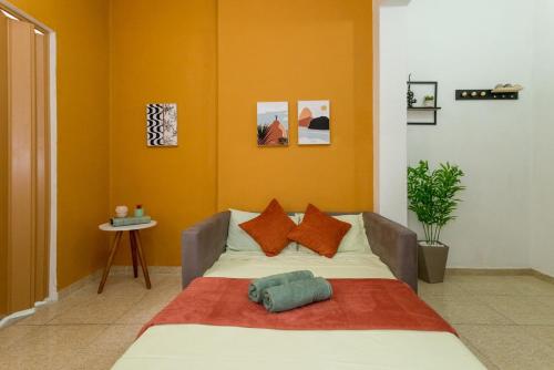 1 dormitorio con 1 cama con paredes de color naranja en Conforto e relax, caminhando para a Praia de Copacabana, Quarto e Sala, completo, com wi fi, cozinha, ar condicionado, en Río de Janeiro