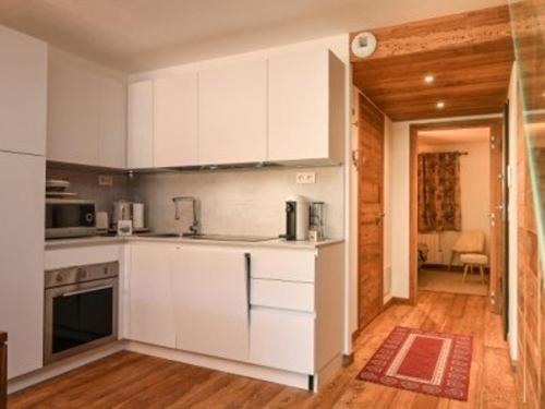 une cuisine avec des armoires blanches et un comptoir dans l'établissement Superbe duplex 4 pièces avec wifi et garage - FR-1-266-158, à Montgenèvre