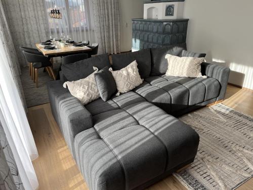 a living room with a black couch and a table at Ferienwohnung Dahoam in Angerberg
