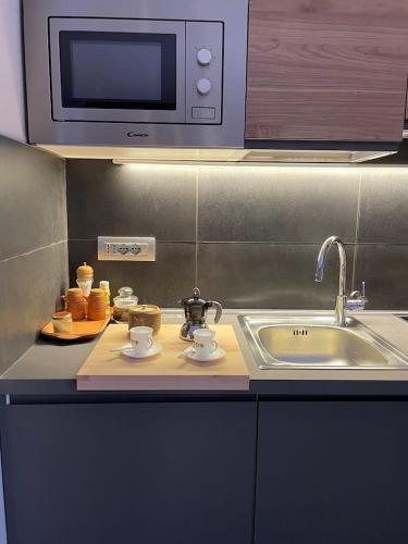 a kitchen counter with a sink and a microwave at Raffinato ed Accogliente Monolocale di Montagna in Breuil-Cervinia