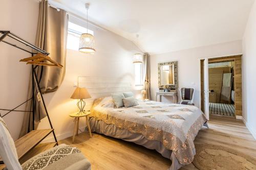 Vertheuil-en-MédocにあるVilla pierre et espace bien etreの大きなベッドと鏡のある寝室