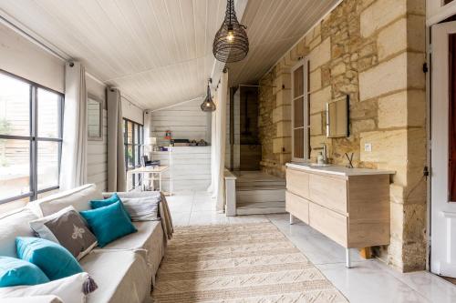 Vertheuil-en-MédocにあるVilla pierre et espace bien etreのソファと洗面台のあるリビングルーム