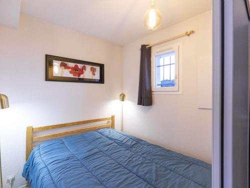 a bedroom with a blue bed and a window at Appartement Cauterets, 2 pièces, 4 personnes - FR-1-401-135 in Cauterets