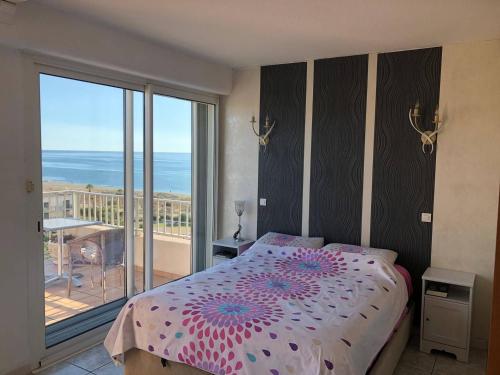 une chambre avec un lit et un balcon avec l'océan dans l'établissement Grand T4 au Barcarès avec Vue Mer et Parking - 3 Chambres, Terrasse, Proche plage - FR-1-81-525, au Barcarès