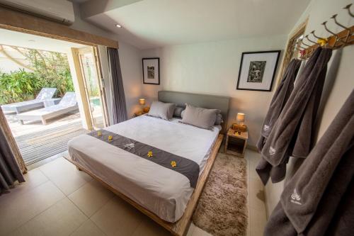 a bedroom with a bed and a sliding glass door at Villa Amana Seminyak in Seminyak