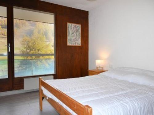 1 dormitorio con cama y ventana grande en Appartement Montgenèvre, 2 pièces, 6 personnes - FR-1-266-161, en Montgenèvre