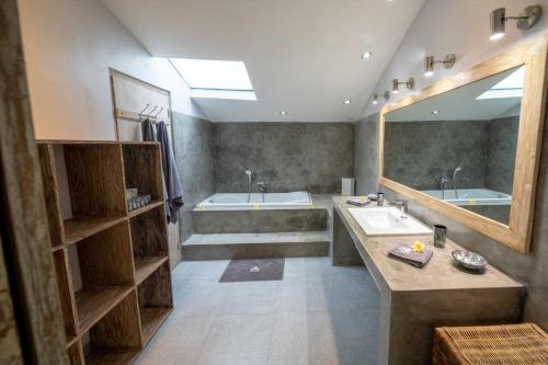 a bathroom with two sinks and a tub and a mirror at Villa Amana Seminyak in Seminyak