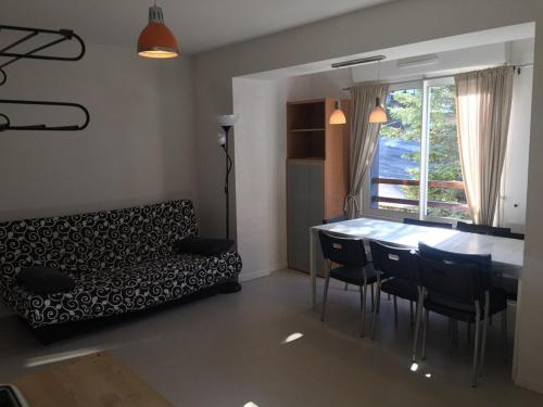 un salon avec un canapé, une table et des chaises dans l'établissement Charmant appartement au pied des pistes, pour 6 personnes avec parking et casier à skis - FR-1-602-61, à Arette