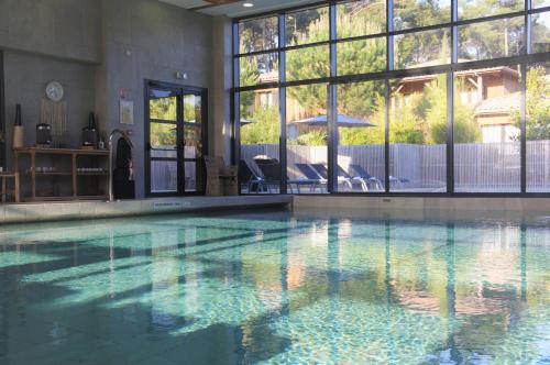 a large swimming pool with a clear blue water at Domaine du Ferret Restaurant & Spa in Cap-Ferret