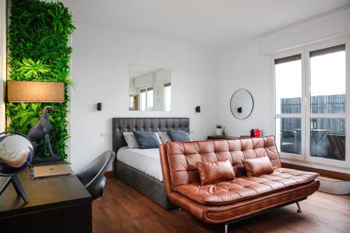 um quarto com uma cama e um sofá de couro em The Attic Centrale - Netflix em Milão