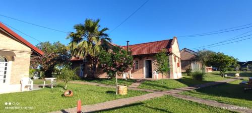 una casa con una palmera en el patio en Cabañas de Ayui en Concordia