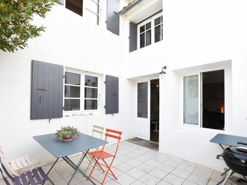 un patio avec une table et des chaises et un bâtiment dans l'établissement Maison de Charme au Centre du Village avec Cheminée et Cuisine Équipée - FR-1-434-56, aux Portes