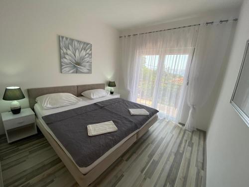 een slaapkamer met een groot bed en een raam bij Holiday home Povile in Novi Vinodolski