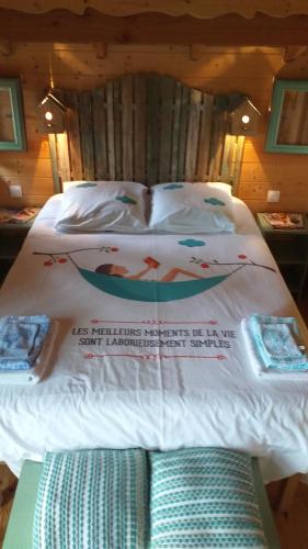 a bed with a sign on it in a room at cabane perchée in Solférino
