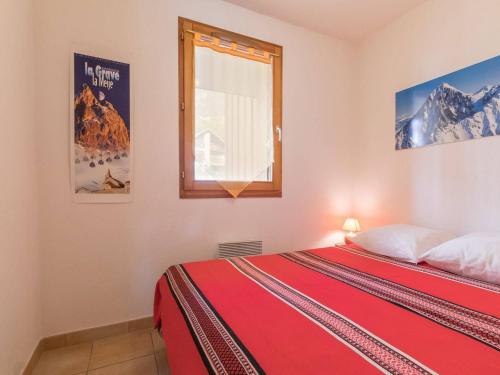 a bedroom with a red bed and a window at Appartement Briançon, 3 pièces, 4 personnes - FR-1-330C-10 in Briançon