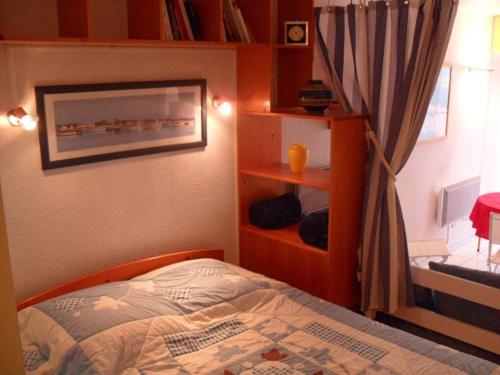 een slaapkamer met een bed en een boekenplank bij Studio Royan, 1 pièce, 3 personnes - FR-1-494-61 in Royan