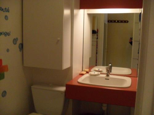 een badkamer met een wastafel, een toilet en een spiegel bij Studio Royan, 1 pièce, 3 personnes - FR-1-494-61 in Royan