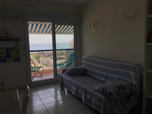 un salon avec un lit et une grande fenêtre dans l'établissement Appartement 2 pièces + cabine avec piscine et parking, 6 couchages, proche plage - Le Barcarès - FR-1-81-473, au Barcarès