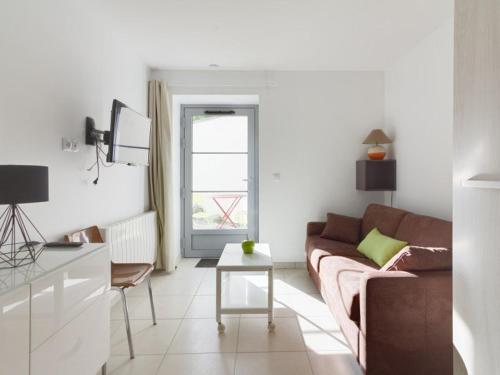 un salon avec un canapé et une table dans l'établissement Studio centre-ville avec terrasse, parking, proche télécabine et commodités - FR-1-401-175, à Cauterets